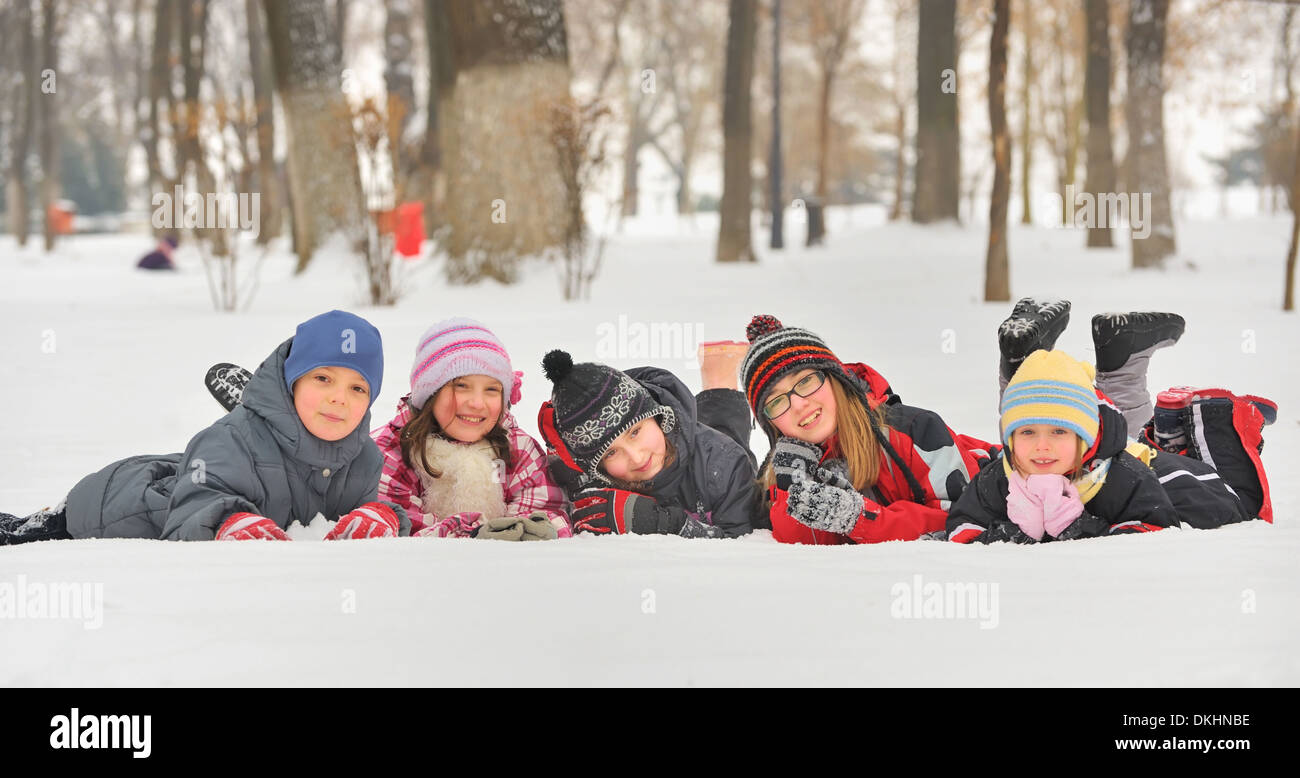 Un gruppo di bambini che giocano sulla neve in inverno Foto Stock