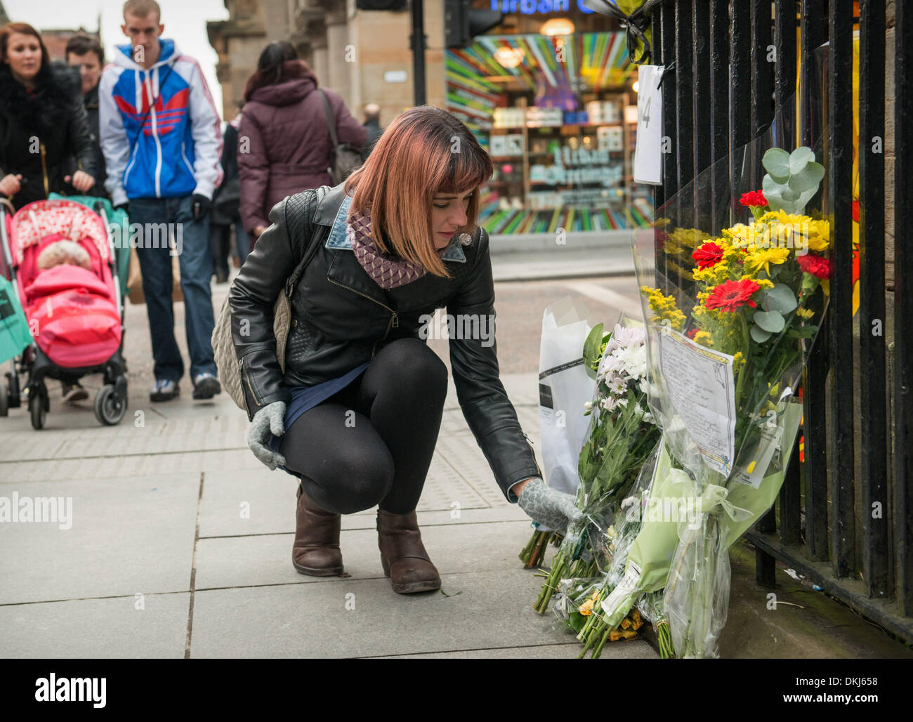 Glasgow Scozia - 06 dicembre: una donna getta fiori in omaggio a Nelason Mandela a ringhiera di Nelson Mandela luogo il 6 dicembre 2013 a Glasgow. Nelson Mandela è stato un leader che hanno aiutato a conquistare l'apartheid in razziale diviso in Sud Africa dopo essere stato incarcerato per il suo attivismo per decenni. Egli è stato il Sud Africa il primo presidente nero. Egli visse da 1918-2013. Credito: Sam Kovak/Alamy Live News Foto Stock