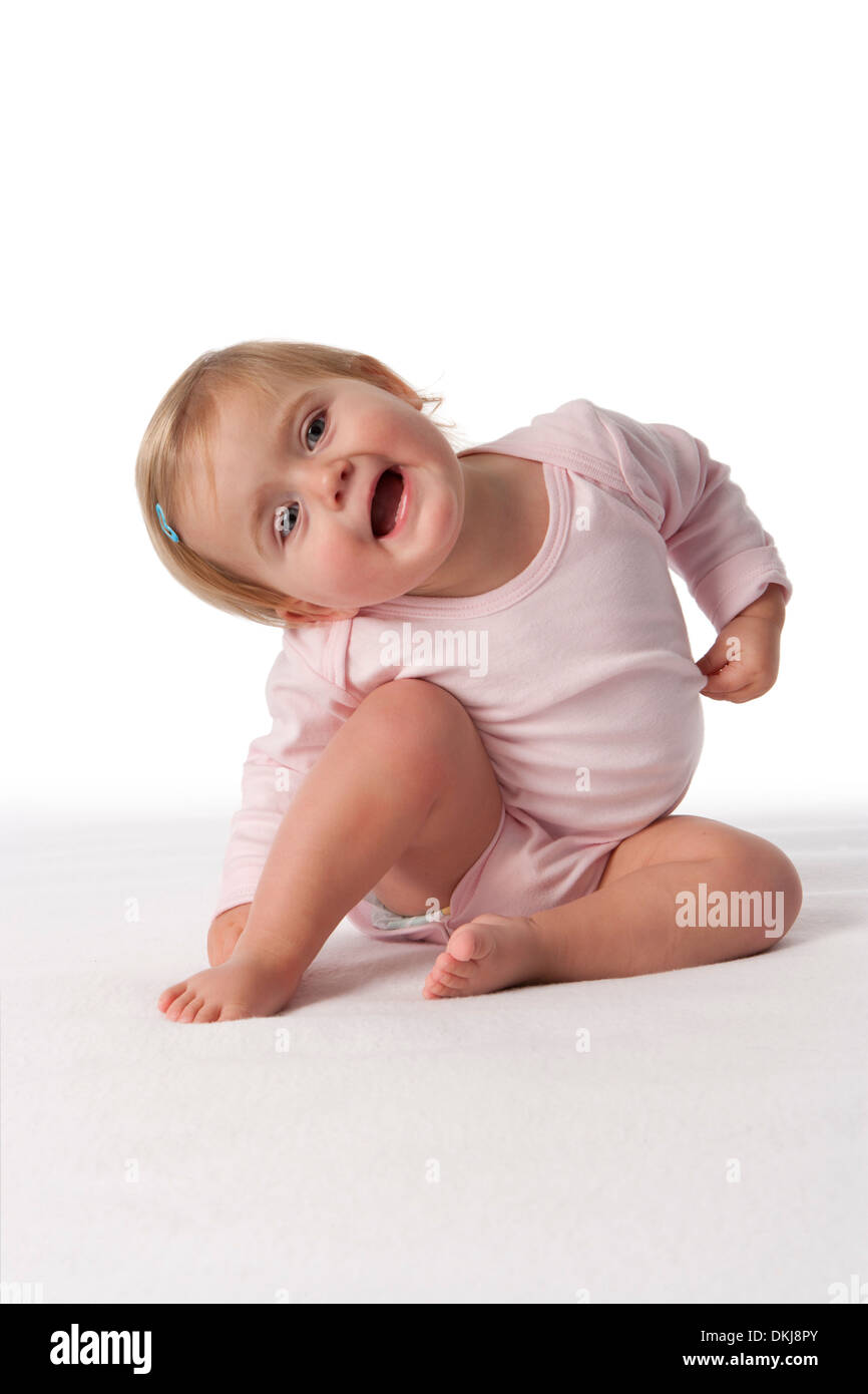 Giocoso toddler ragazza seduta sul pavimento Foto Stock