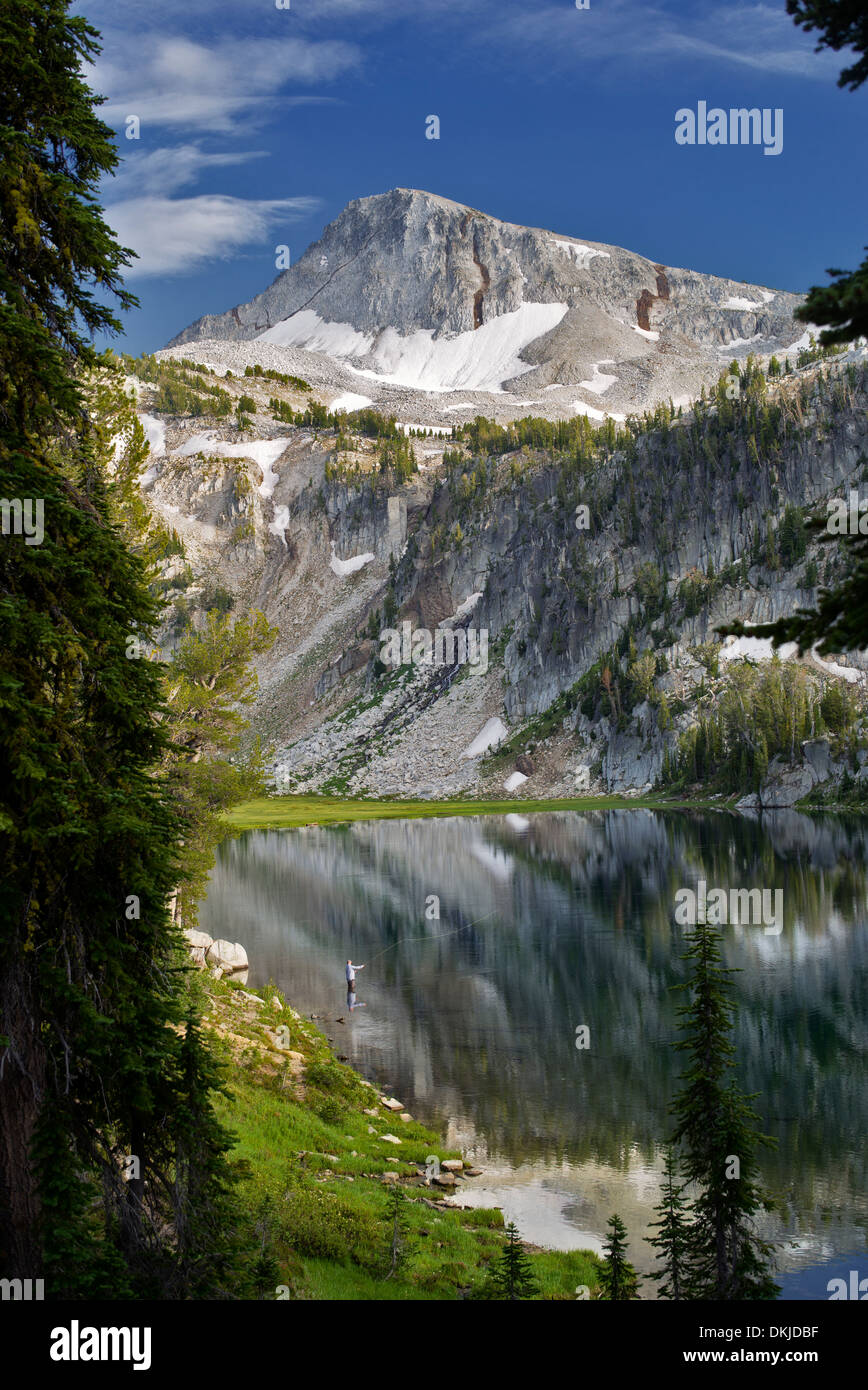 Pescatore a mosca e di riflessione nel lago a specchio con cappuccio Eagle Mountain. Eagle Cap deserto, Oregon Foto Stock
