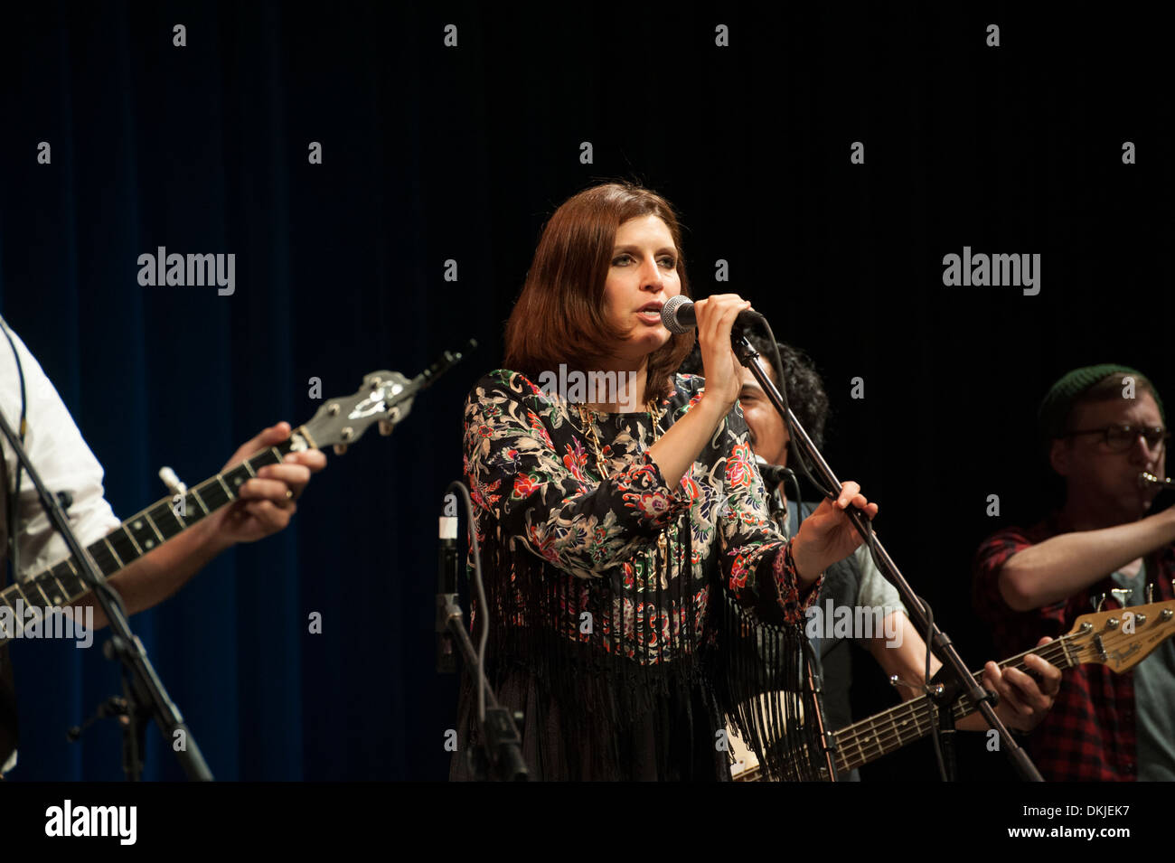 Una donna cantare, accompagnato da altri musicisti. Foto Stock