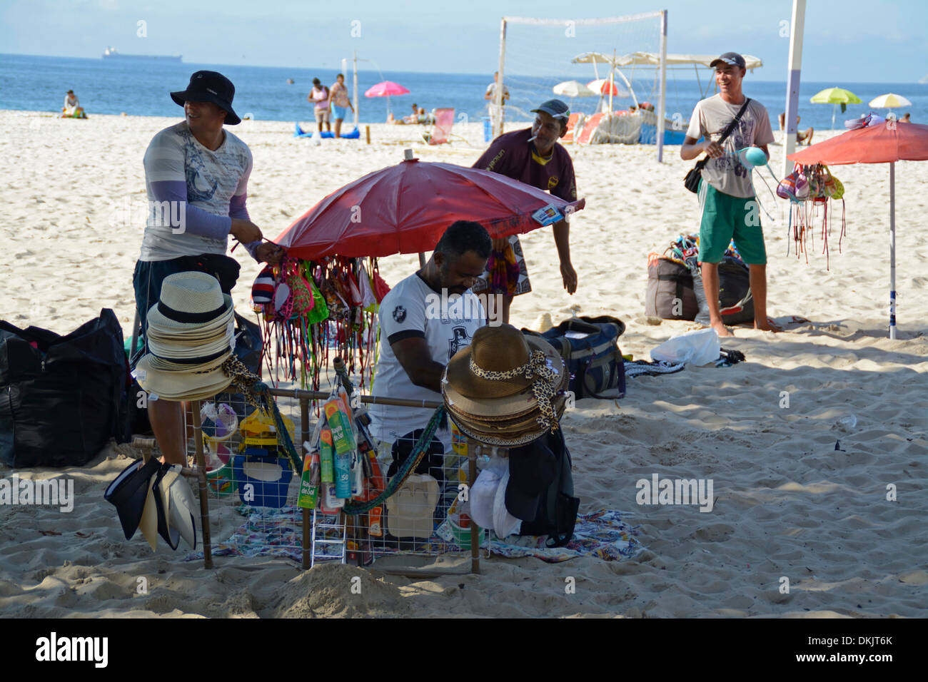 I falchi della spiaggia sono occupati a preparare i loro articoli per la vendita prima di pettinare Copacabana Beach a Rio de Janeiro, Brasile Foto Stock