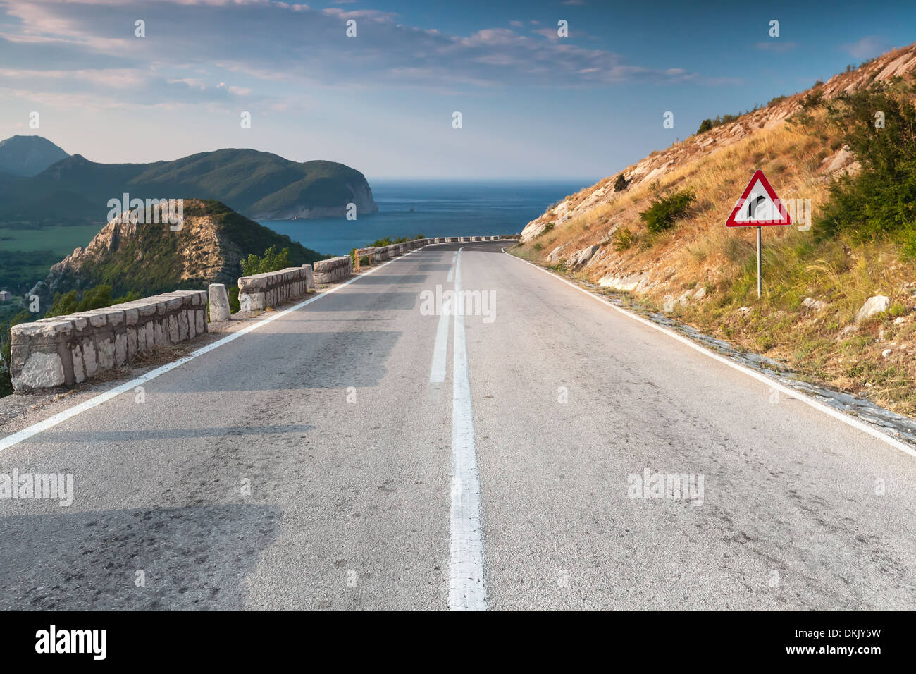 Linea di demarcazione e sterzata a destra cartello sulla costiera autostrada di montagna. Montenegro Foto Stock