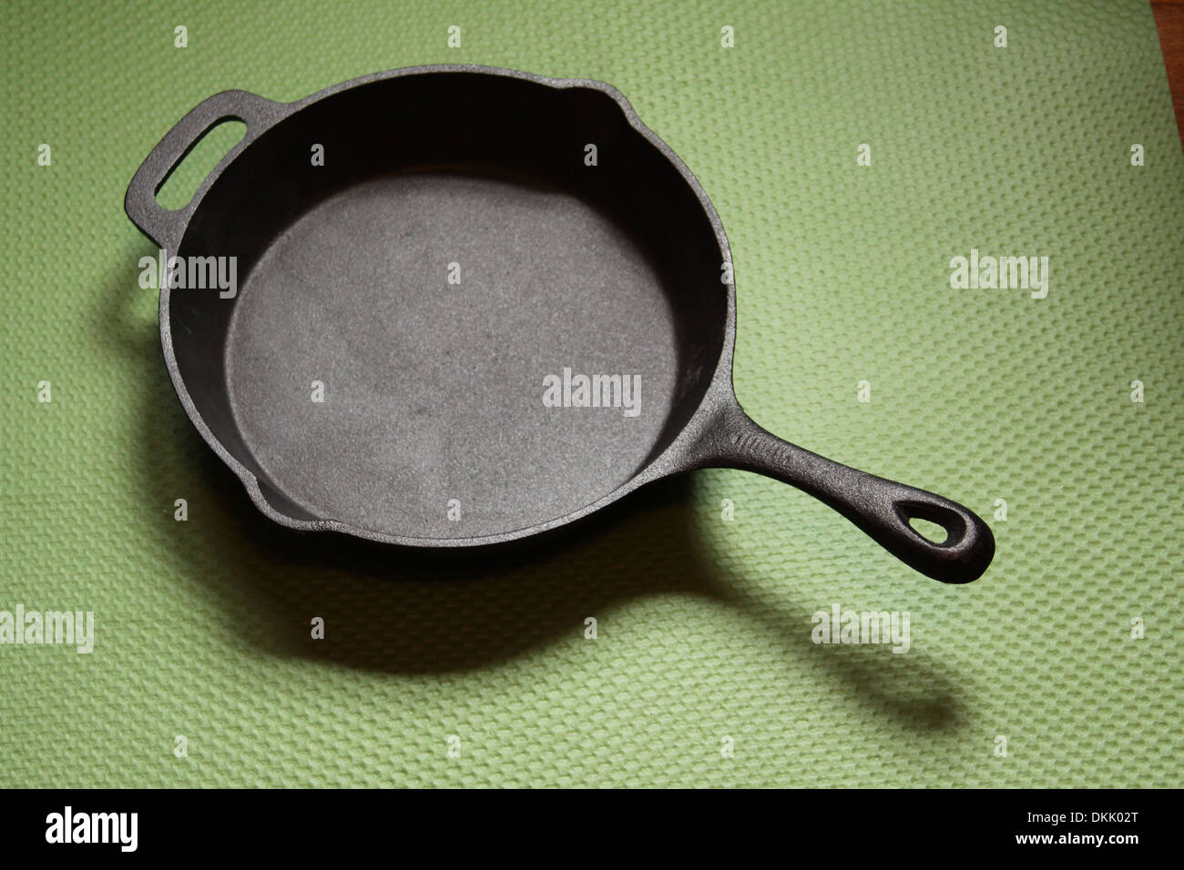 Scrigno padella di ferro su un tappeto verde Foto Stock