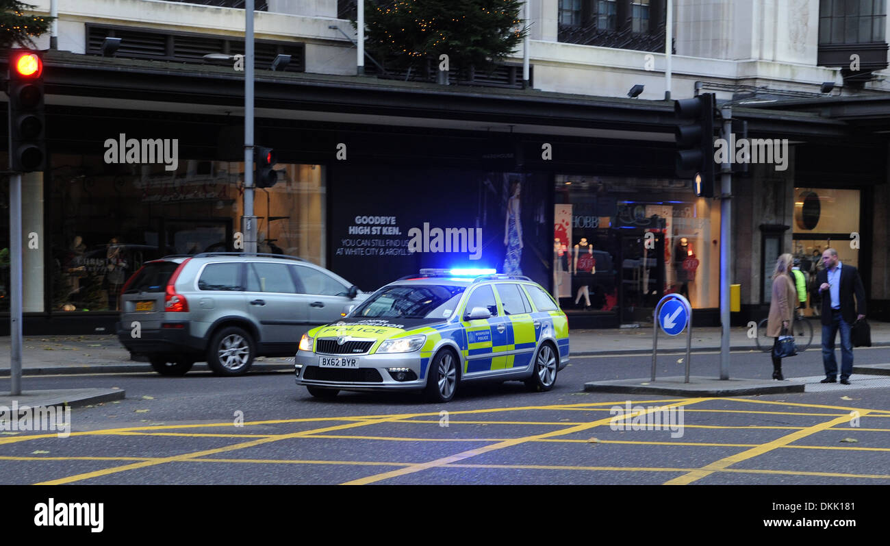 Metropolitan Police auto con luci blu lampeggiante su chiamata di emergenza in Kensington High Street Londra UK Foto Stock