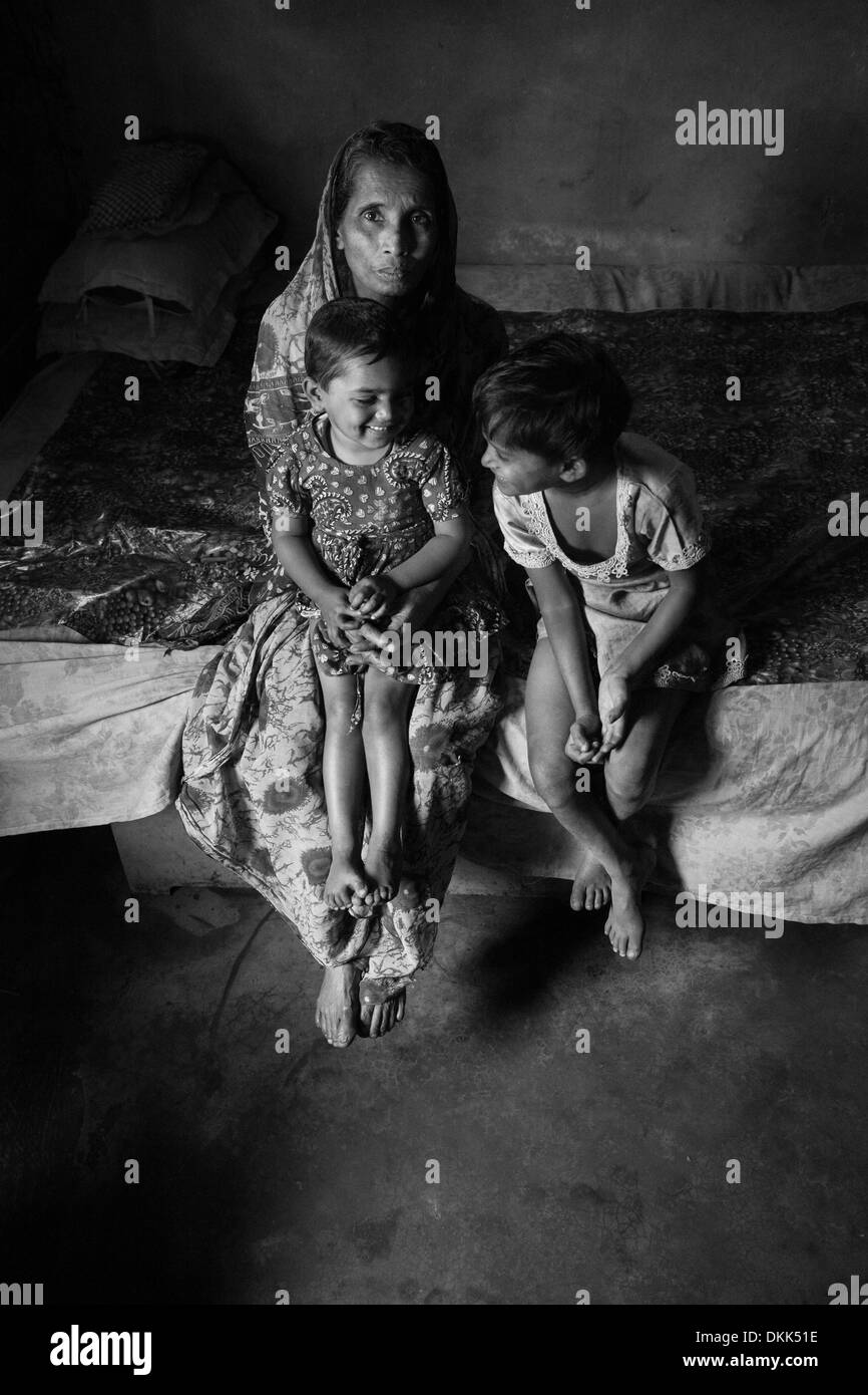 Saidpur, Bangladesh. Il 30 marzo, 2013. Una famiglia Bihari sedersi nella loro camera singola casa per una fotografia all'interno di un campo in Bangladesh. 42 anni dopo la guerra del 1971 ci sono ancora circa 600.000 Biharis (noto anche come "pachistani irrecuperabili') vivono in Bangladesh. © Hanna Adcock/ZUMA filo/ZUMAPRESS.com/Alamy Live News Foto Stock