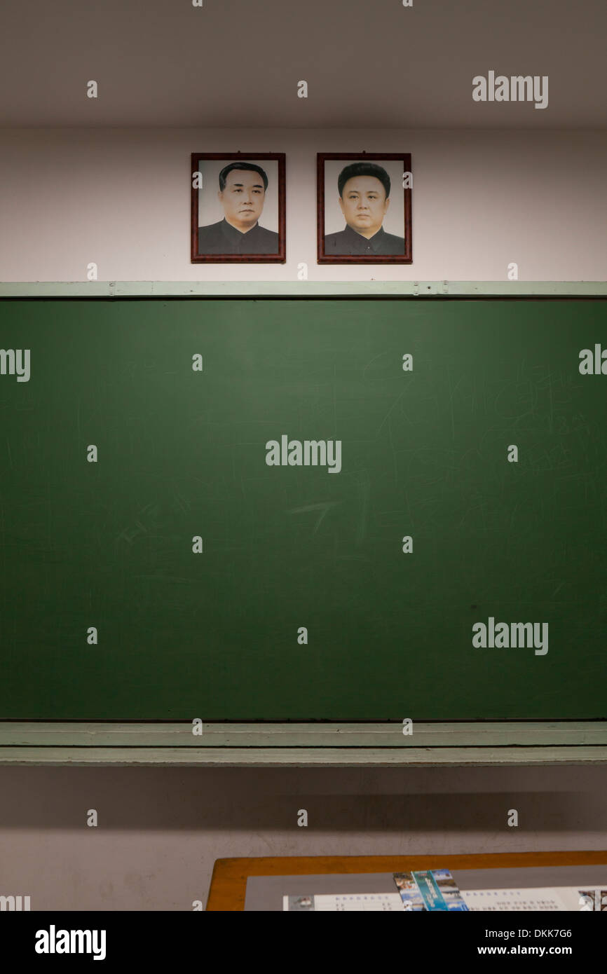 Mock-up della Corea del Nord in aula della scuola la visualizzazione di ritratti di Kim Il Sung e Kim Jong Il al di sopra di Blackboard Foto Stock