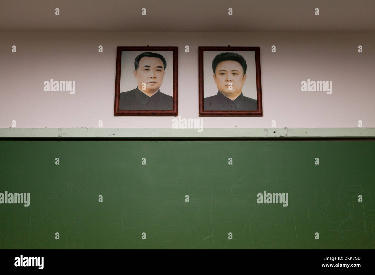 Mock-up della Corea del Nord in aula della scuola la visualizzazione di ritratti di Kim Il Sung e Kim Jong Il al di sopra di Blackboard Foto Stock