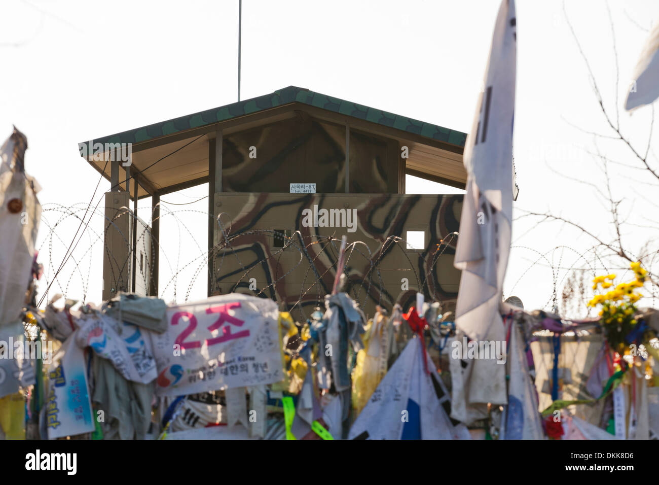 Le bandiere e messaggi di pace e di unificazione coprire la recinzione a sud coreano torre di avvistamento militare lungo la zona neutrale (DMZ) Foto Stock