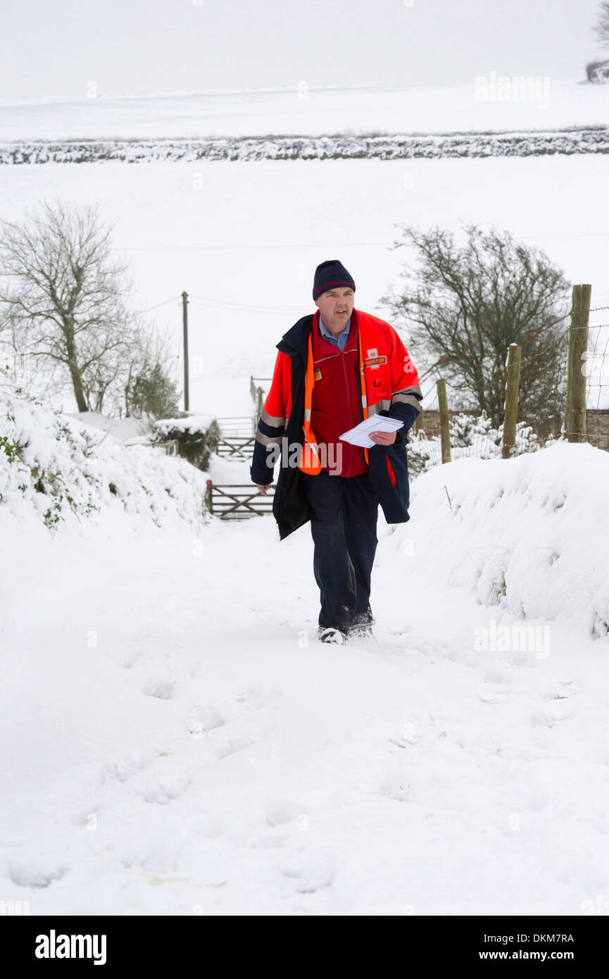 Un postino consegna la posta per case a trefoli in Challacombe, Devon, Regno Unito durante il periodo invernale Foto Stock