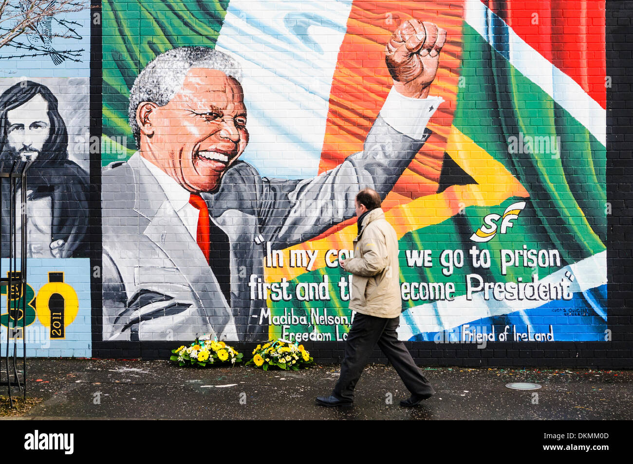 Belfast, Irlanda del Nord. 7 Dic 2013 - Un uomo guarda omaggi floreali a sinistra a Mandela Murale in seguito alla morte di Nelson Mandela il 5 dicembre. Credito: Stephen Barnes/Alamy Live News Foto Stock