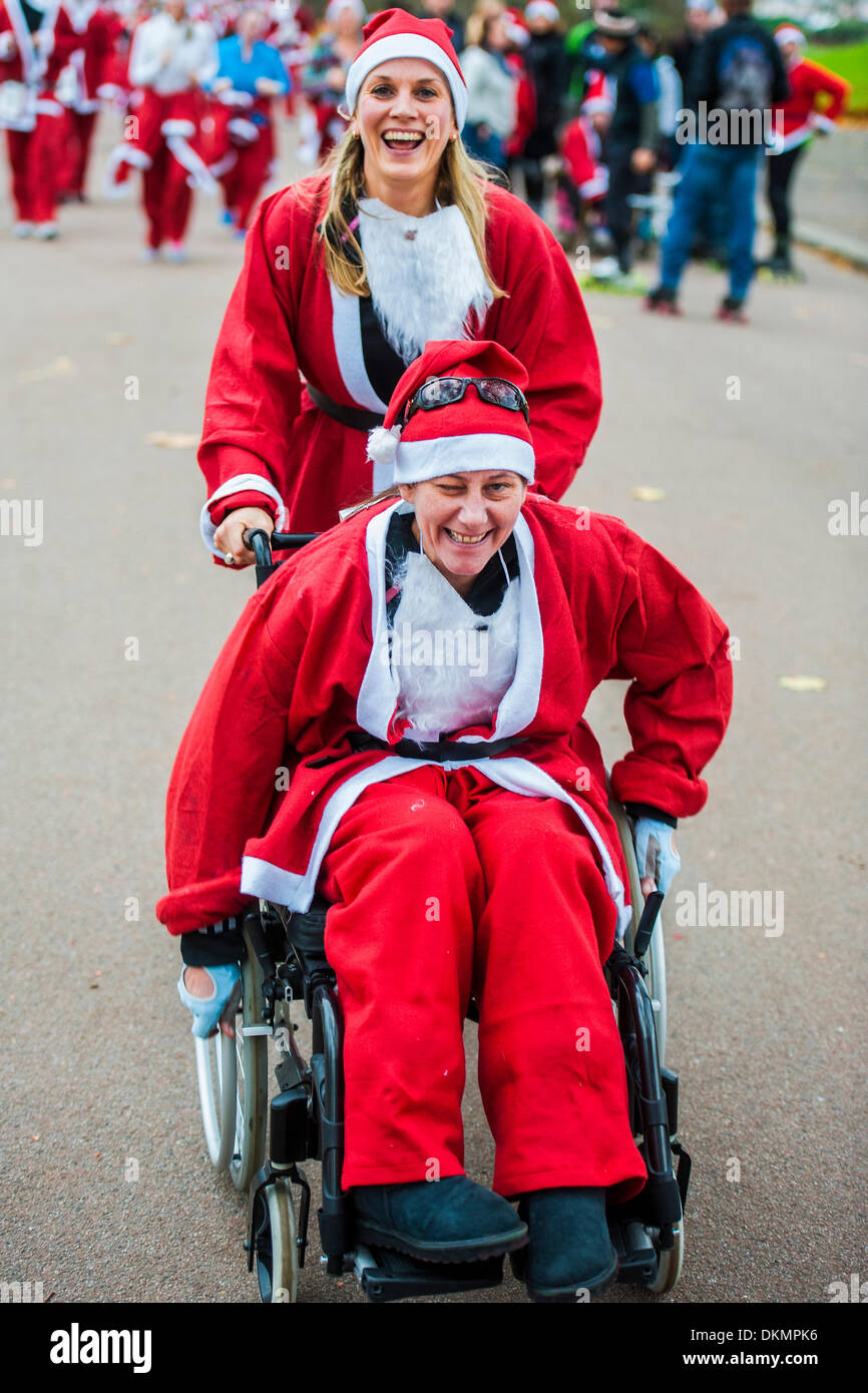 Londra, Regno Unito. 07Th Dec, 2013. Il London Santa Run, un 6k carità festive fun run, con circa 2.000 Santa's. Esso è organizzato per raccogliere fondi per la Disabilità Snowsport UK, una carità nazionale per aiutare le persone con disabilità per accedere il brivido di sport invernali. Battersea Park, London, Regno Unito 07 Dic 2013. Credito: Guy Bell/Alamy Live News Foto Stock