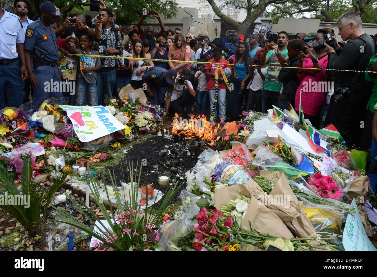 JOHANNESBURG, SUD AFRICA: scoppia un incendio tra i fiori che sono tra le migliaia di omaggi a ex presidente Nelson su dicembre 7, 2013 a Johannesburg, in Sud Africa. Il padre della patria, Nelson Mandela, Tata Madiba, passate tranquillamente la sera del 5 dicembre 2013 nella sua casa di Houghton con la famiglia. Credito: Gallo immagini/Alamy Live News Foto Stock