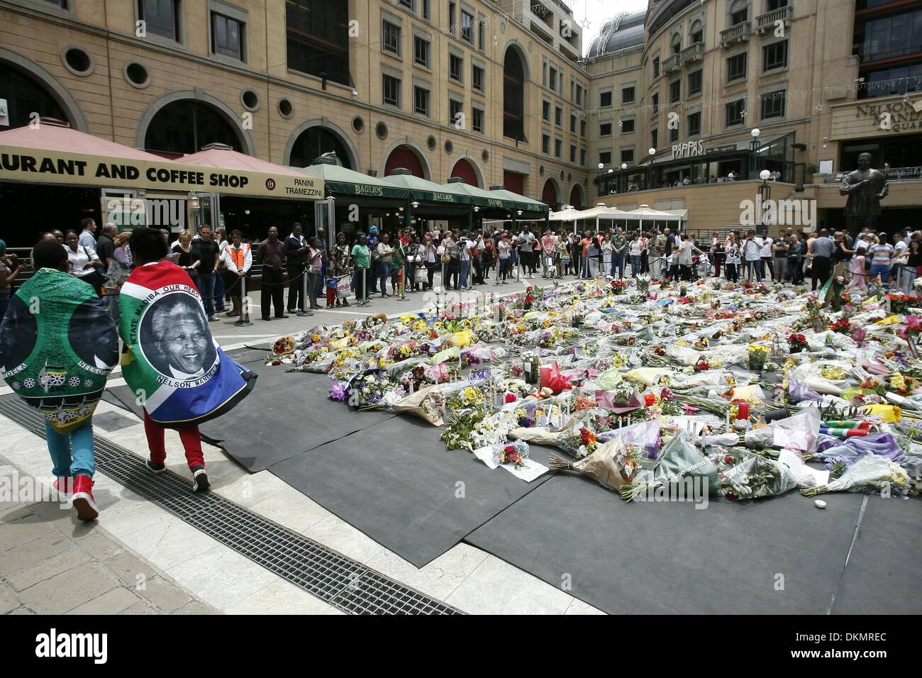 SANDTON, SUD AFRICA: migliaia di persone in lutto lasciare fiori a Nelson Mandela Square il 7 dicembre 2013 a Johannesburg, in Sud Africa. Persone in lutto sono state raccolte dal prime ore della mattina per pagare i loro punti di vista. Il padre della patria, Nelson Mandela, Tata Madiba, passate tranquillamente la sera del 5 dicembre 2013 nella sua casa di Houghton con la famiglia. Credito: Gallo immagini/Alamy Live News Foto Stock