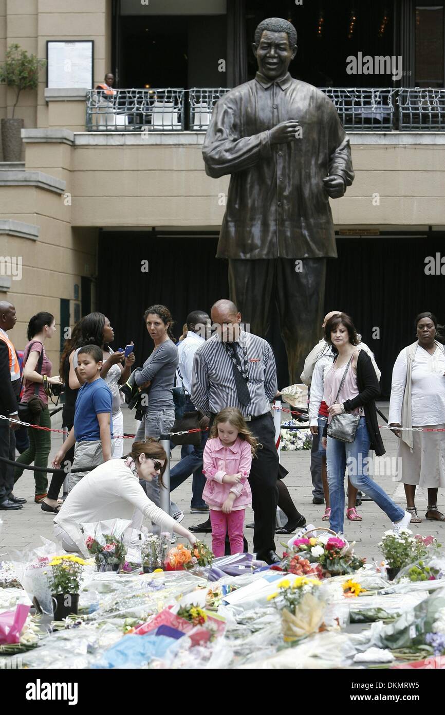 SANDTON, SUD AFRICA: migliaia di persone in lutto lasciare fiori a Nelson Mandela Square il 7 dicembre 2013 a Johannesburg, in Sud Africa. Persone in lutto sono state raccolte dal prime ore della mattina per pagare i loro punti di vista. Il padre della patria, Nelson Mandela, Tata Madiba, passate tranquillamente la sera del 5 dicembre 2013 nella sua casa di Houghton con la famiglia. Credito: Gallo immagini/Alamy Live News Foto Stock