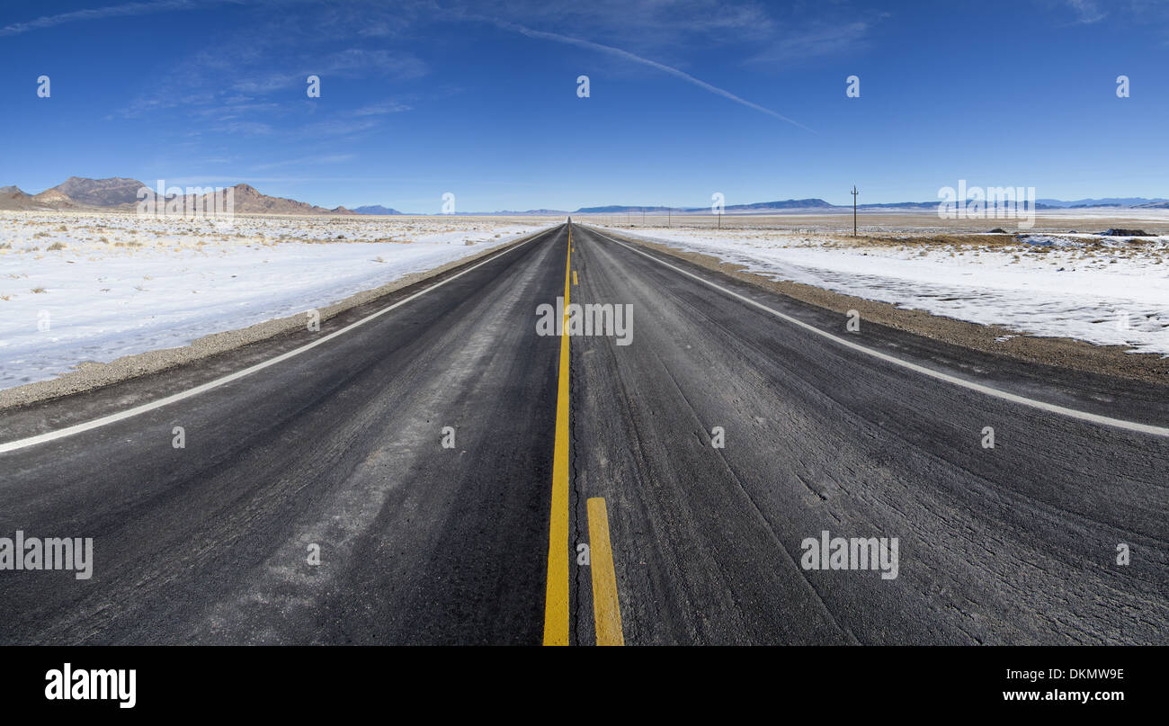 Un rettilineo a sezione aperta della autostrada 6 strada in Nevada si estende al lontano orizzonte in inverno Foto Stock