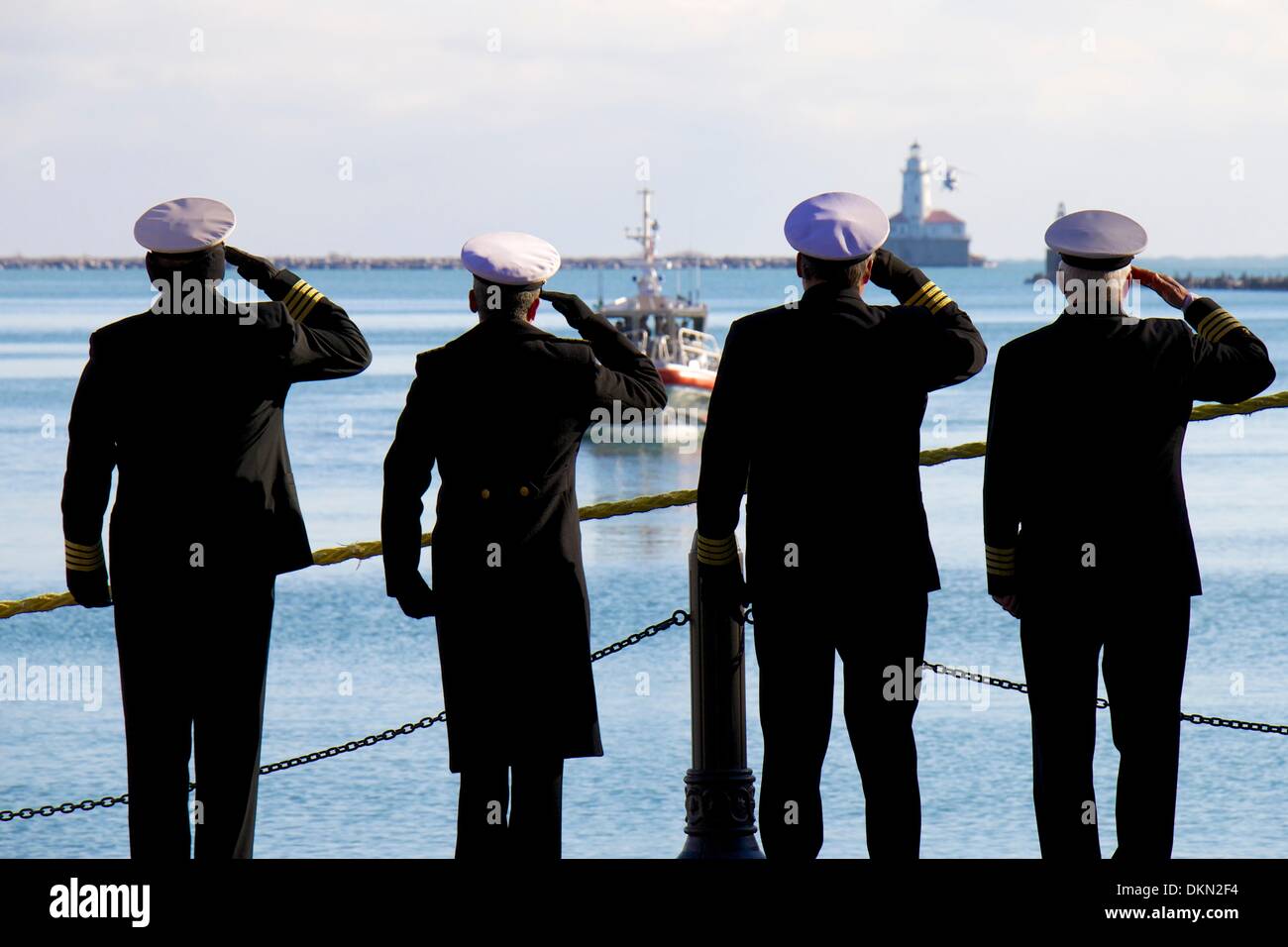 Chicago, Illinois, Stati Uniti d'America. Il 7 dicembre 2013. Membri della International Associazione Shipmasters salutate come una corona è scesa da un elicottero vicino al faro di Chicago durante l annuale albero di Natale nave cerimonia al Navy Pier. L'evento è in memoria di la goletta Rouse Simmons, l'originale albero di Natale nave, che è stato perso con tutte le mani durante una tempesta il 23 novembre 1912. Credito: Todd Bannor/Alamy Live News Foto Stock