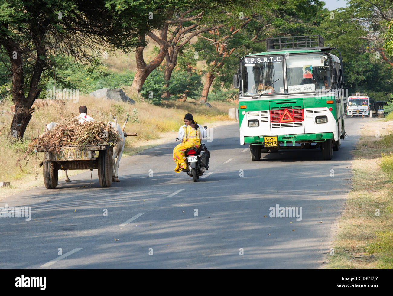 Bus indiano, carrello di giovenco e il motociclo su una strada di campagna. Andhra Pradesh, India Foto Stock