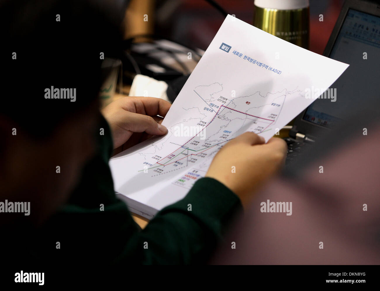 Seoul, Corea del Sud. L'8 dicembre, 2013. Un sud coreano media reporter contiene una mappa di un'aria espansa di difesa zona di identificazione (KADIZ) nel corso di una conferenza stampa per una expanded KADIZ presso il Ministero della Difesa Nazionale di Seoul, Corea del Sud, 8 dicembre, 2013. La Corea del sud ha deciso di espandere la propria difesa aerea della zona di identificazione (KADIZ) verso Sud Seoul il Ministero della Difesa ha detto in una teletrasmesso press briefing di domenica. Credito: Park Jin-hee/Xinhua/Alamy Live News Foto Stock