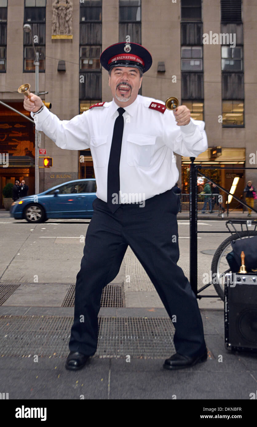 Un esercito della salvezza volontario cantare, ballare e suonare le campane durante la raccolta in Midtown Manhattan, a New York City Foto Stock