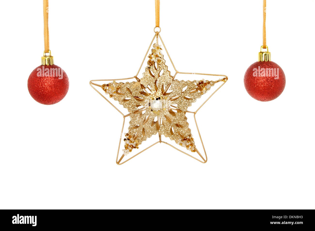 Oro e jeweled stella di Natale e rosso glitter baubles appeso da nastro isolata contro bianco Foto Stock