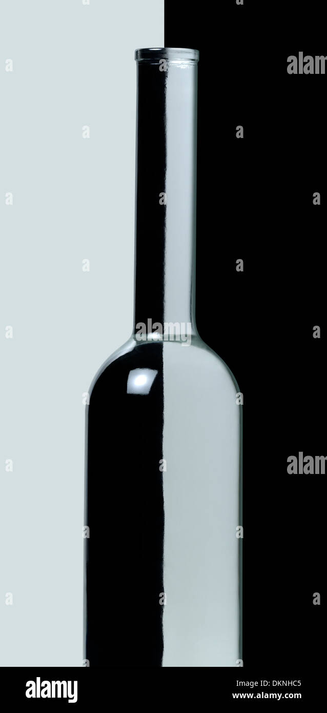 Bottiglia di vetro chiaro nella parte anteriore della luce e lo sfondo scuro Foto Stock