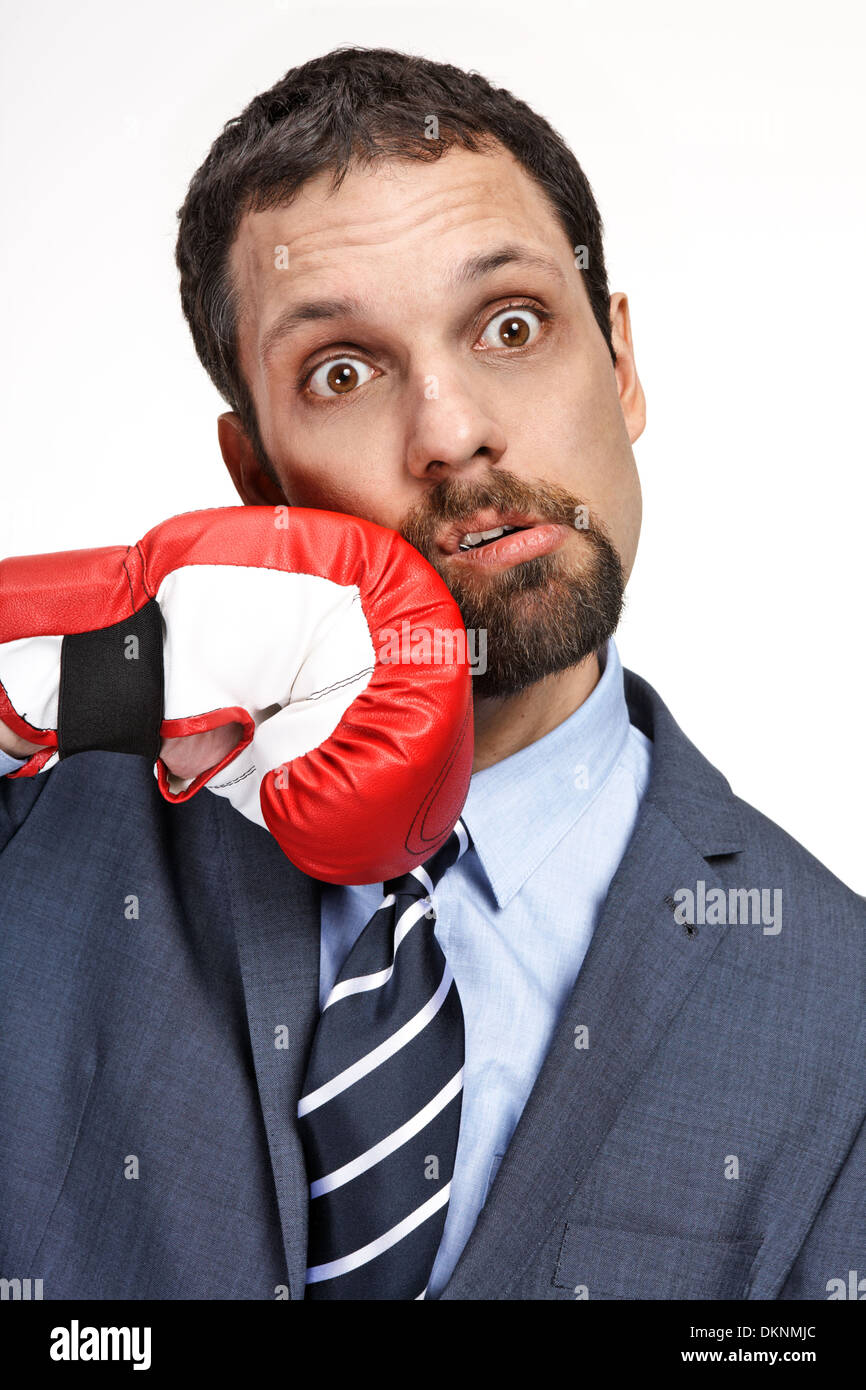 Close-up aziendali giovane uomo colpito da mano nel guanto di boxe Foto Stock
