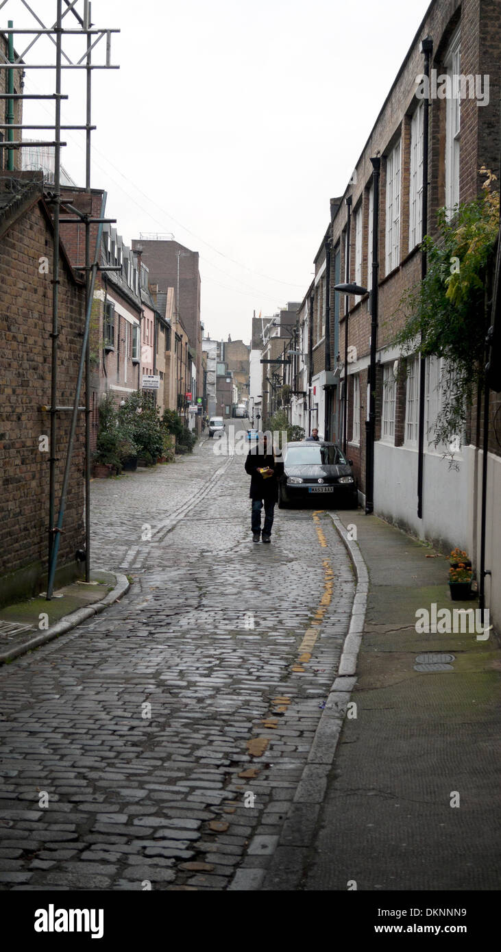 Una persona che cammina lungo Brownlow Mews appena fuori di Guilford Street e Grays Inn Road a Londra WC1 KATHY DEWITT Foto Stock