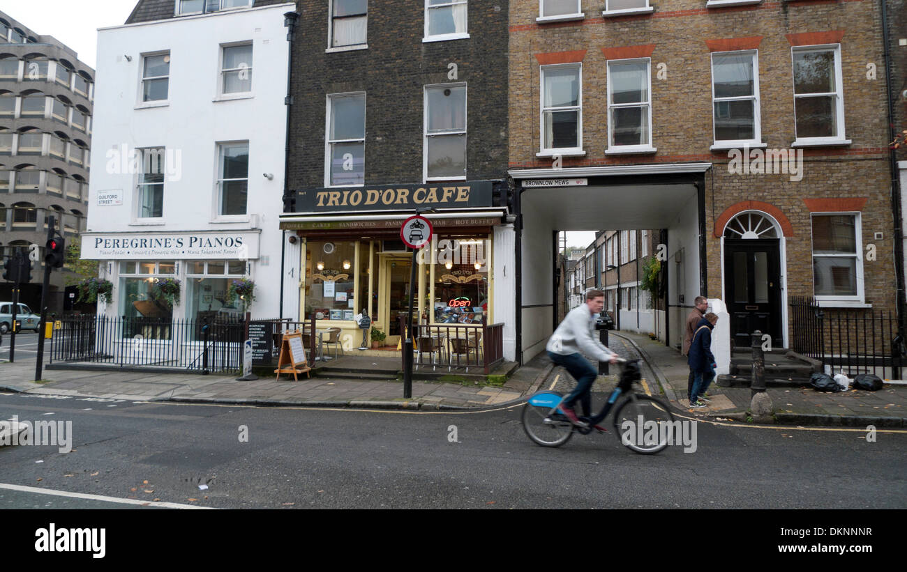 Un uomo in bicicletta lungo Guilford Street passato Brownlow Mews corner Grays Inn Road London WC1 KATHY DEWITT Foto Stock