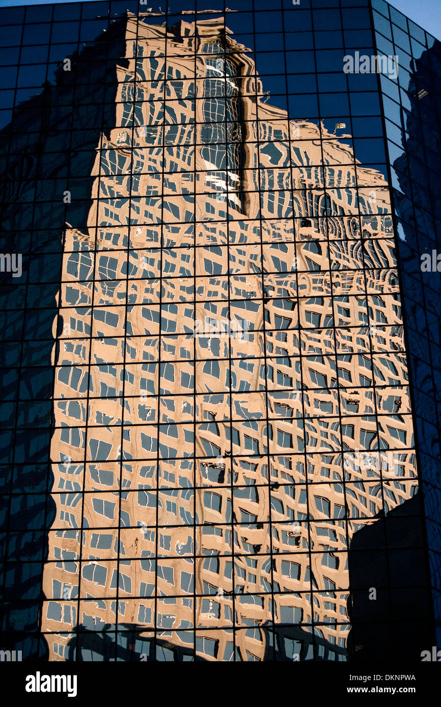 La riflessione di un edificio dalla facciata in vetro di un altro edificio per uffici. Foto Stock