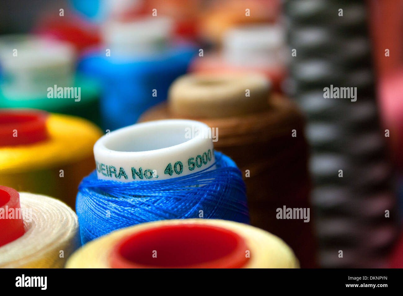 Un gruppo di cucitura di bobine di filo di vari colori, profondità di campo. Foto Stock