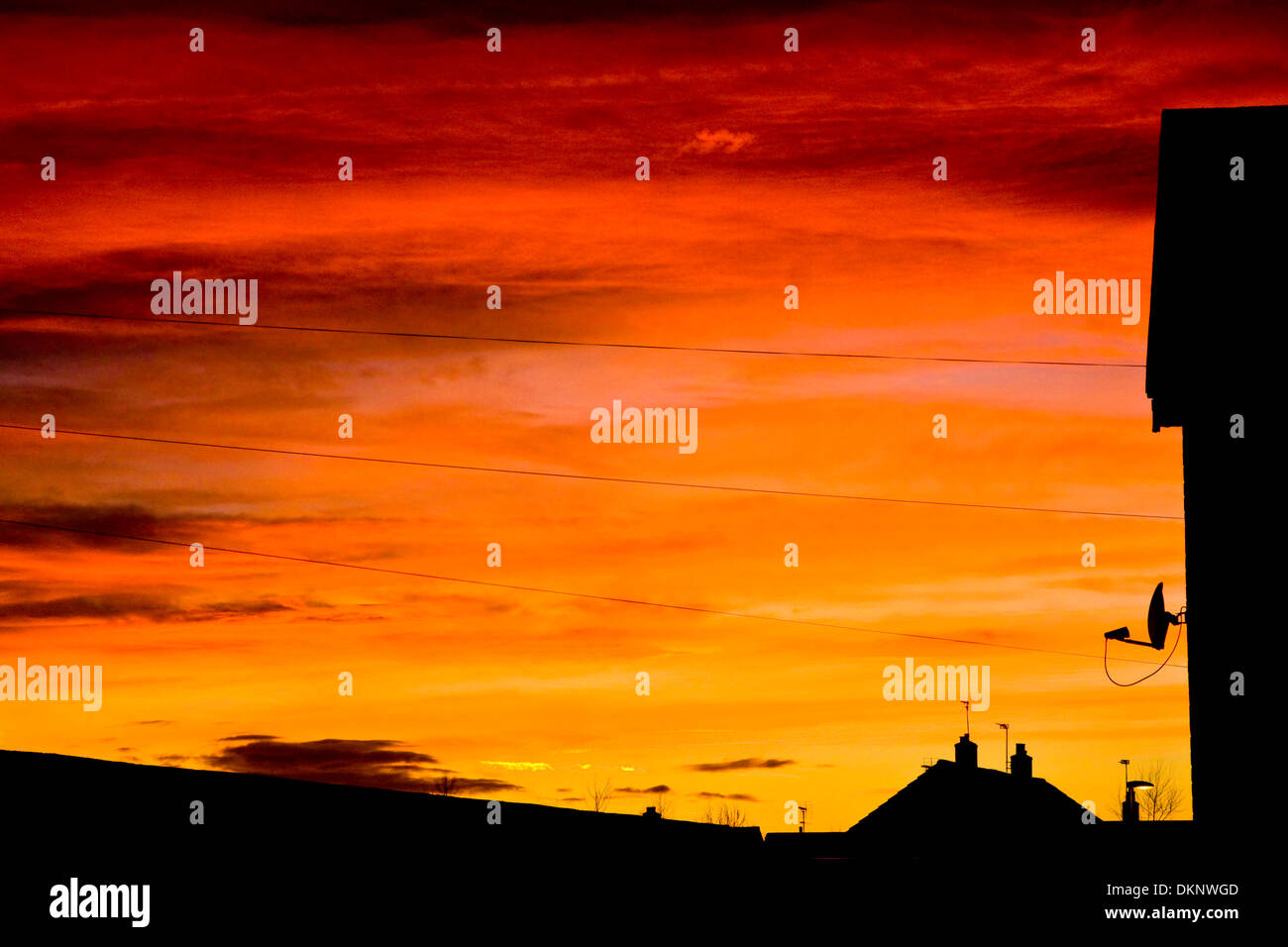 Sky TV piatto e casa tetti in silhouette al tramonto sulla strada del castello, Mountsorrel Foto Stock
