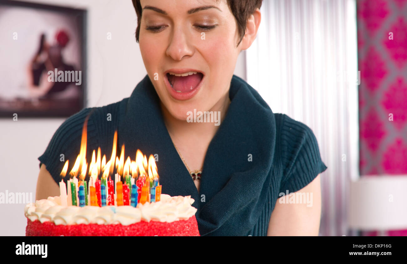 Compleanno candele bruciano destra prima donna soffia loro fuori Foto Stock