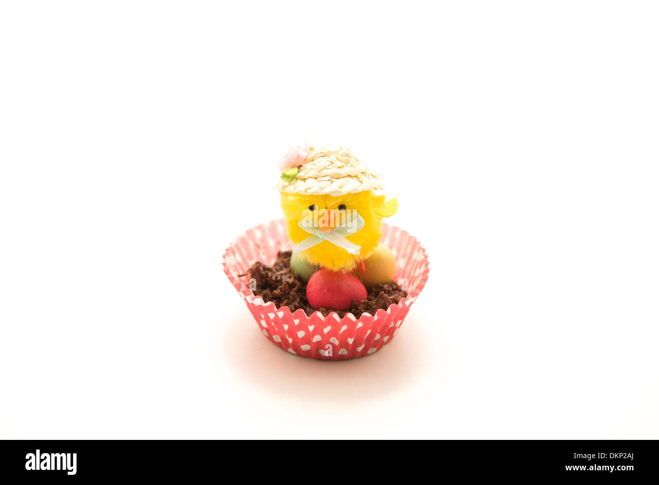 Piccolo giallo pulcino di Pasqua giocattolo seduto su un uovo di cioccolato nest Foto Stock