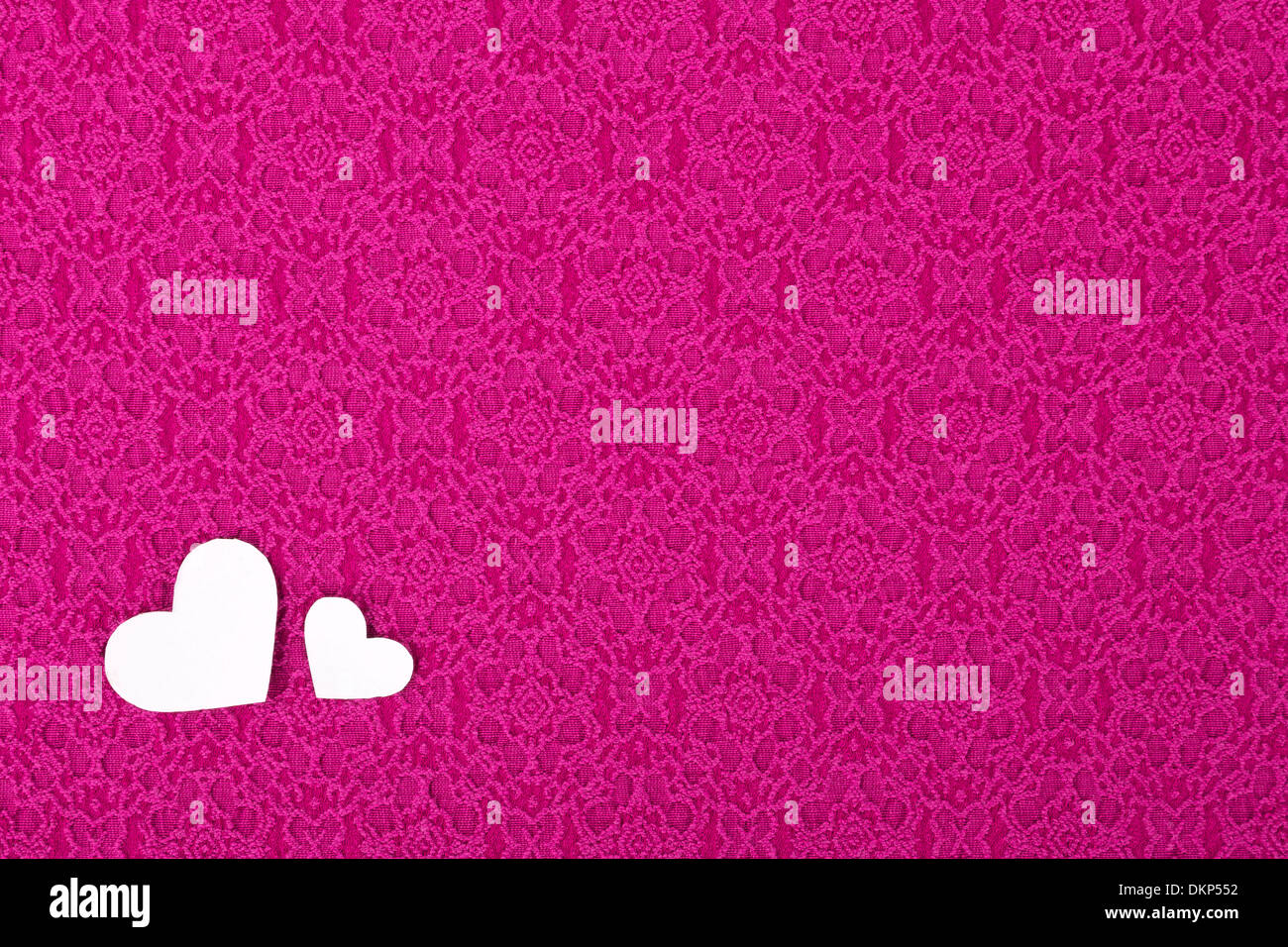Il materiale di colore rosa con due cuori, sullo sfondo, il giorno di San Valentino. Foto Stock