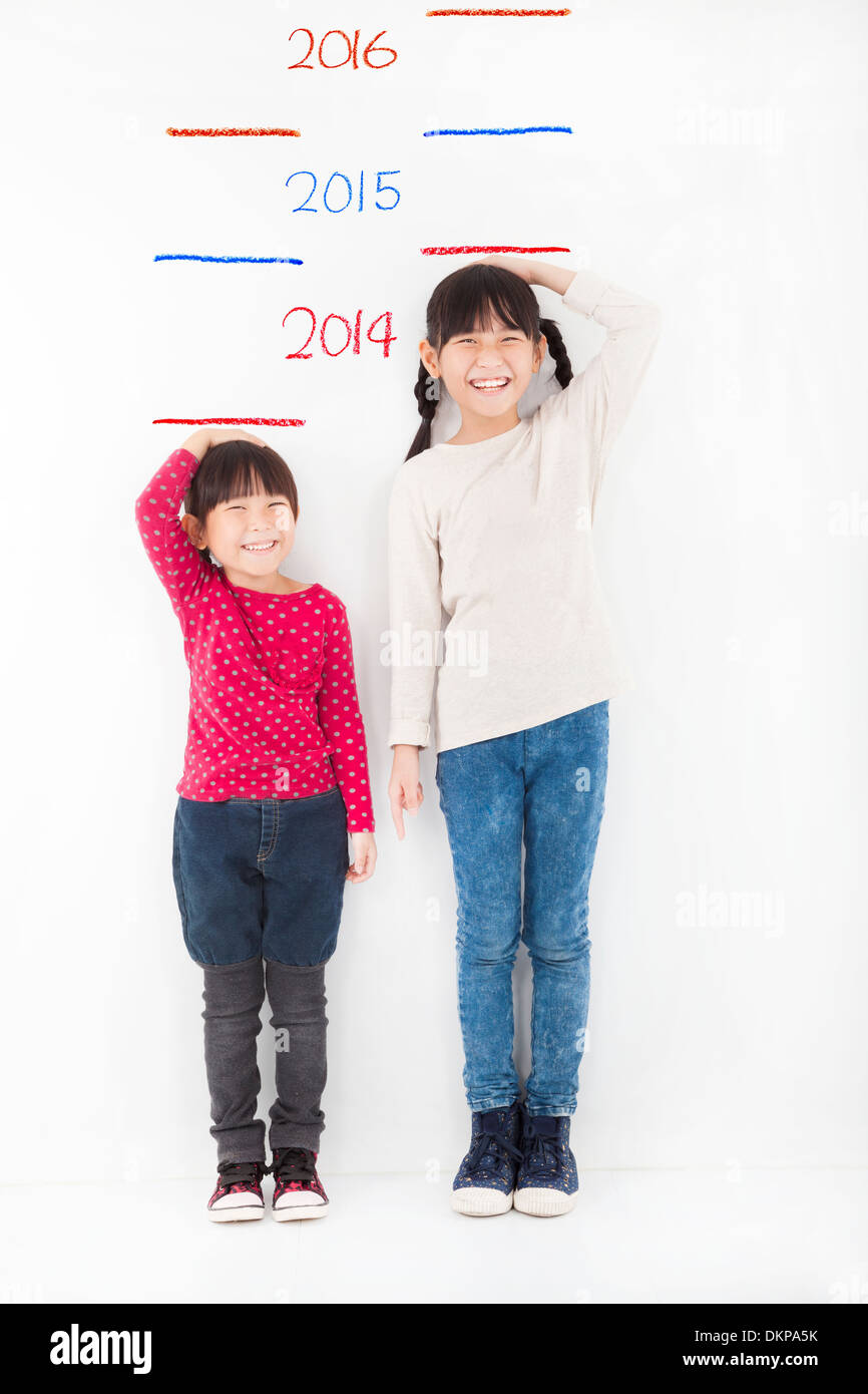 Felici i bambini crescono e contro il muro Foto Stock