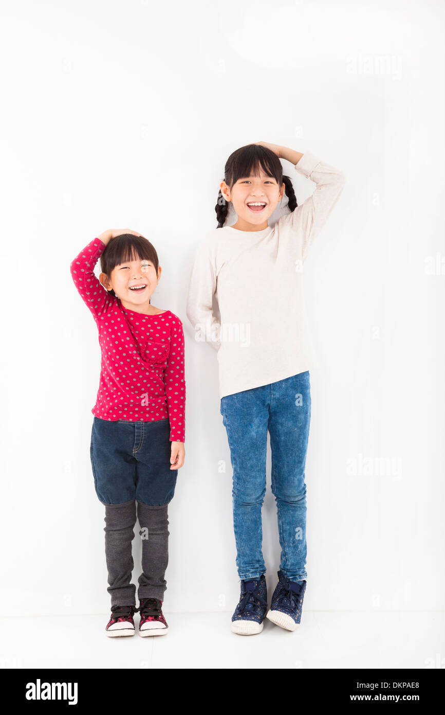 Dei bambini felici davanti a muro bianco Foto Stock