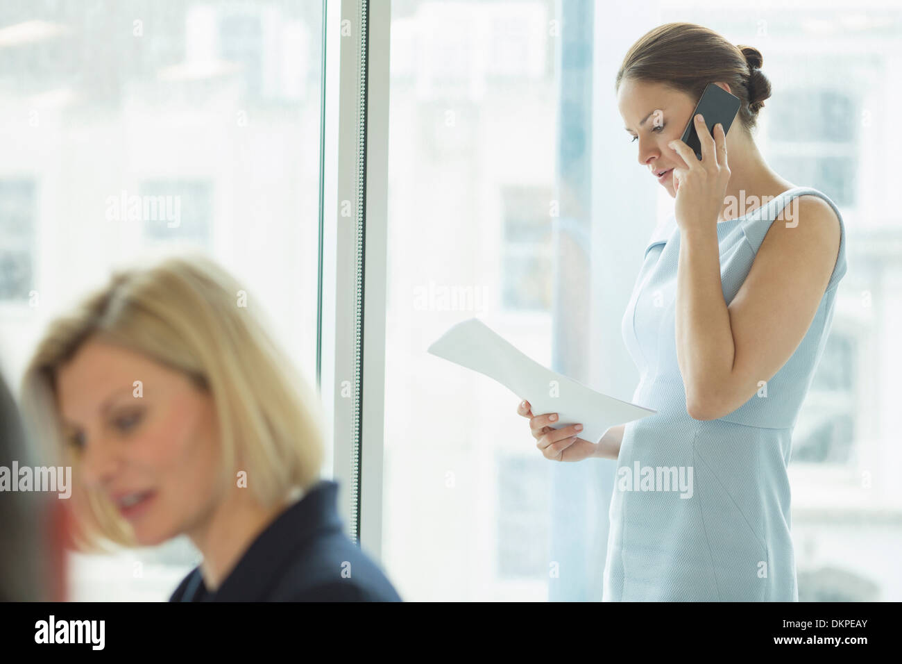 Imprenditrice parlando al cellulare in ufficio Foto Stock