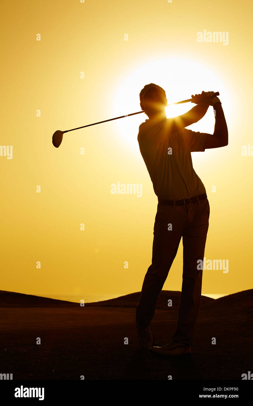 Silhouette di uomo swinging golf club Foto Stock