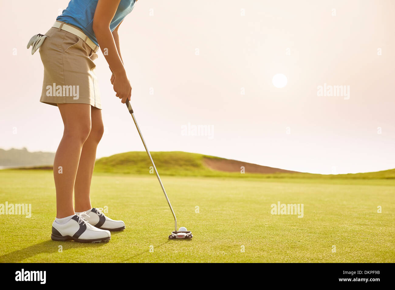 Donna mettendo sul campo da golf Foto Stock