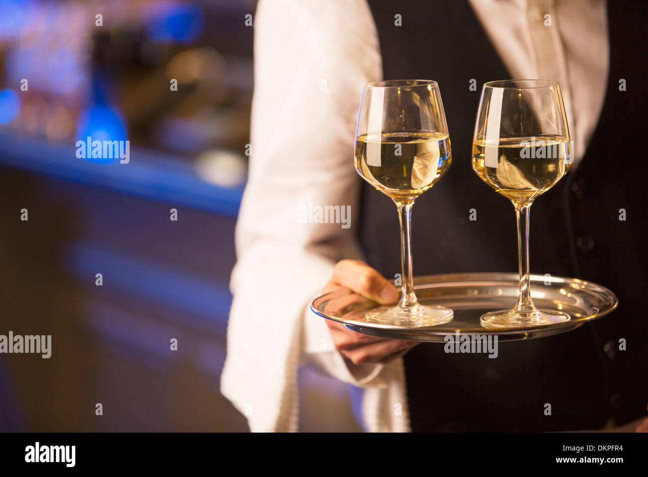 Close up barista bianco porta bicchieri di vino sul vassoio Foto Stock
