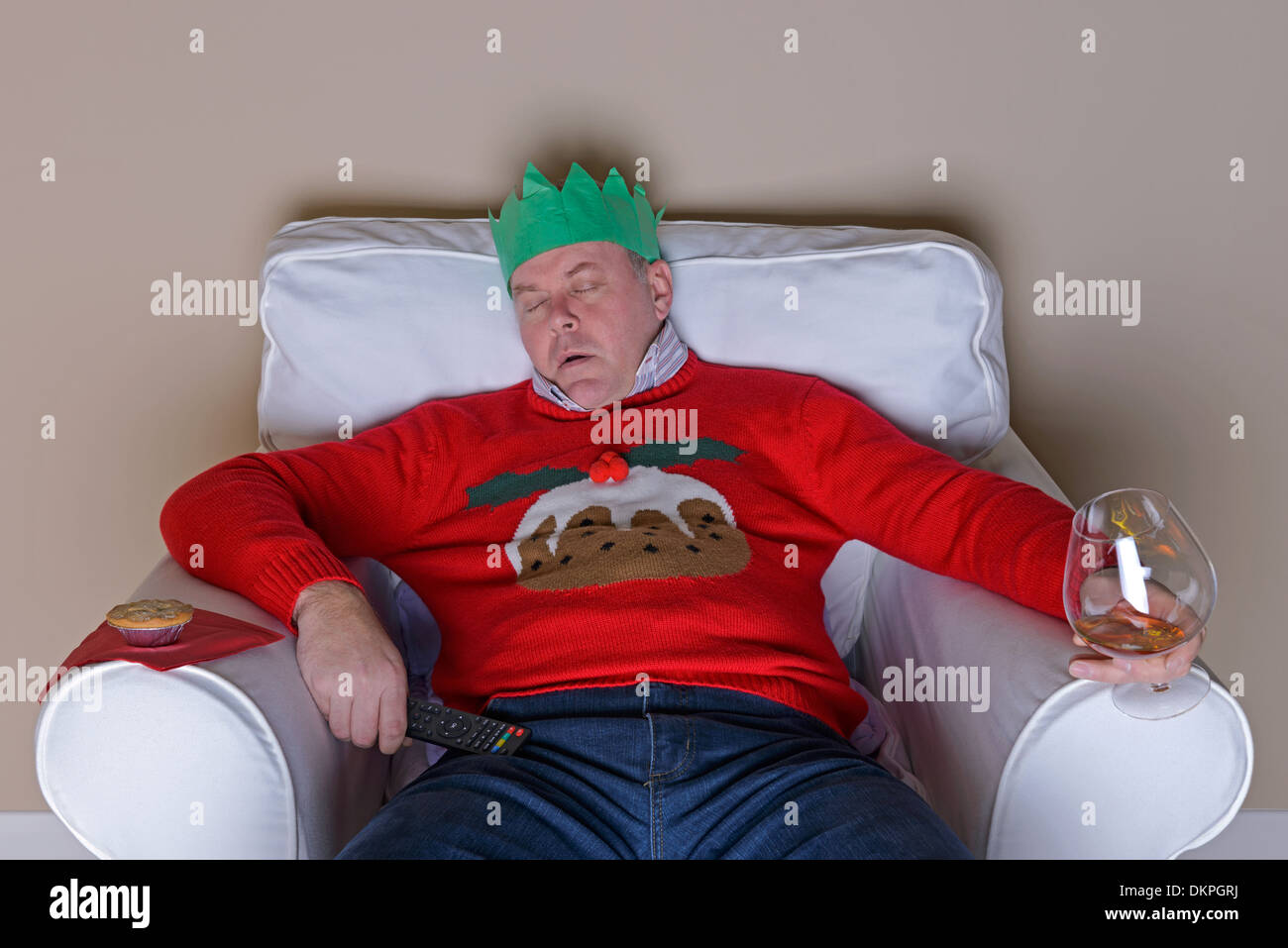Una tradizione di Natale - papà è caduto addormentato in una poltrona dopo cena davanti alla TV Foto Stock