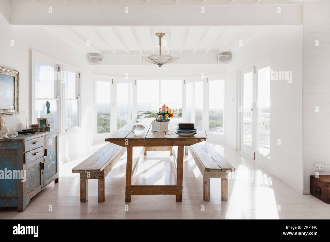 Tavolo in legno e panche nella soleggiata sala da pranzo Foto Stock