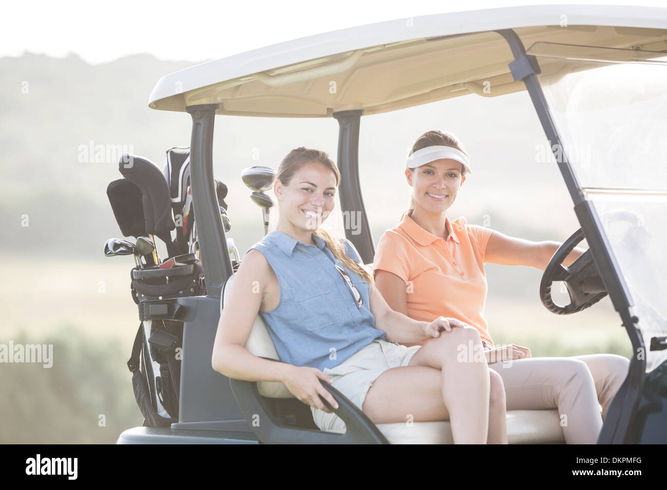 Le donne la guida carrello da golf sul corso Foto Stock