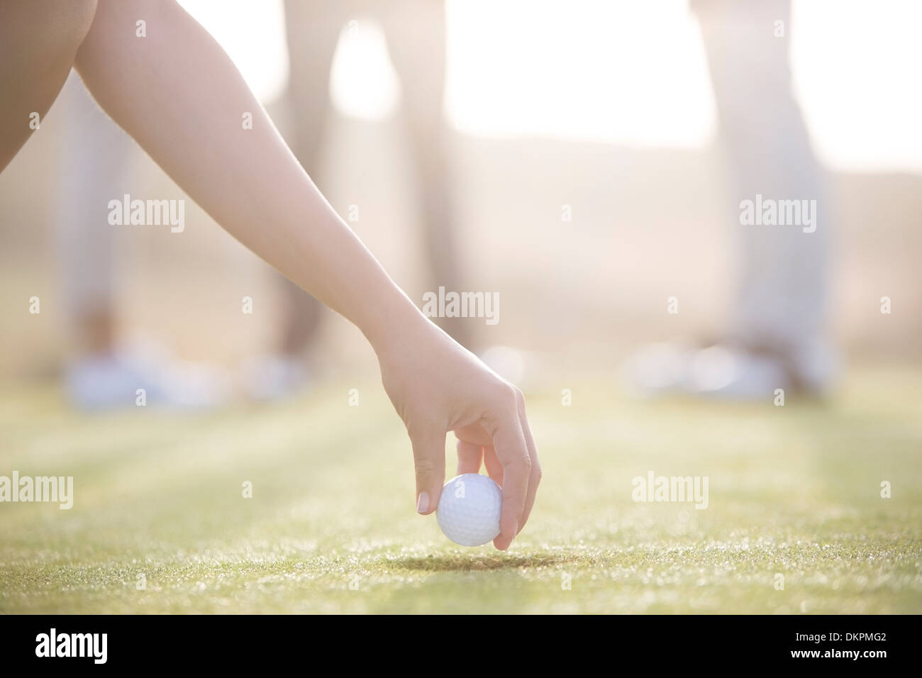Donna di rinvio pallina da golf sul corso Foto Stock