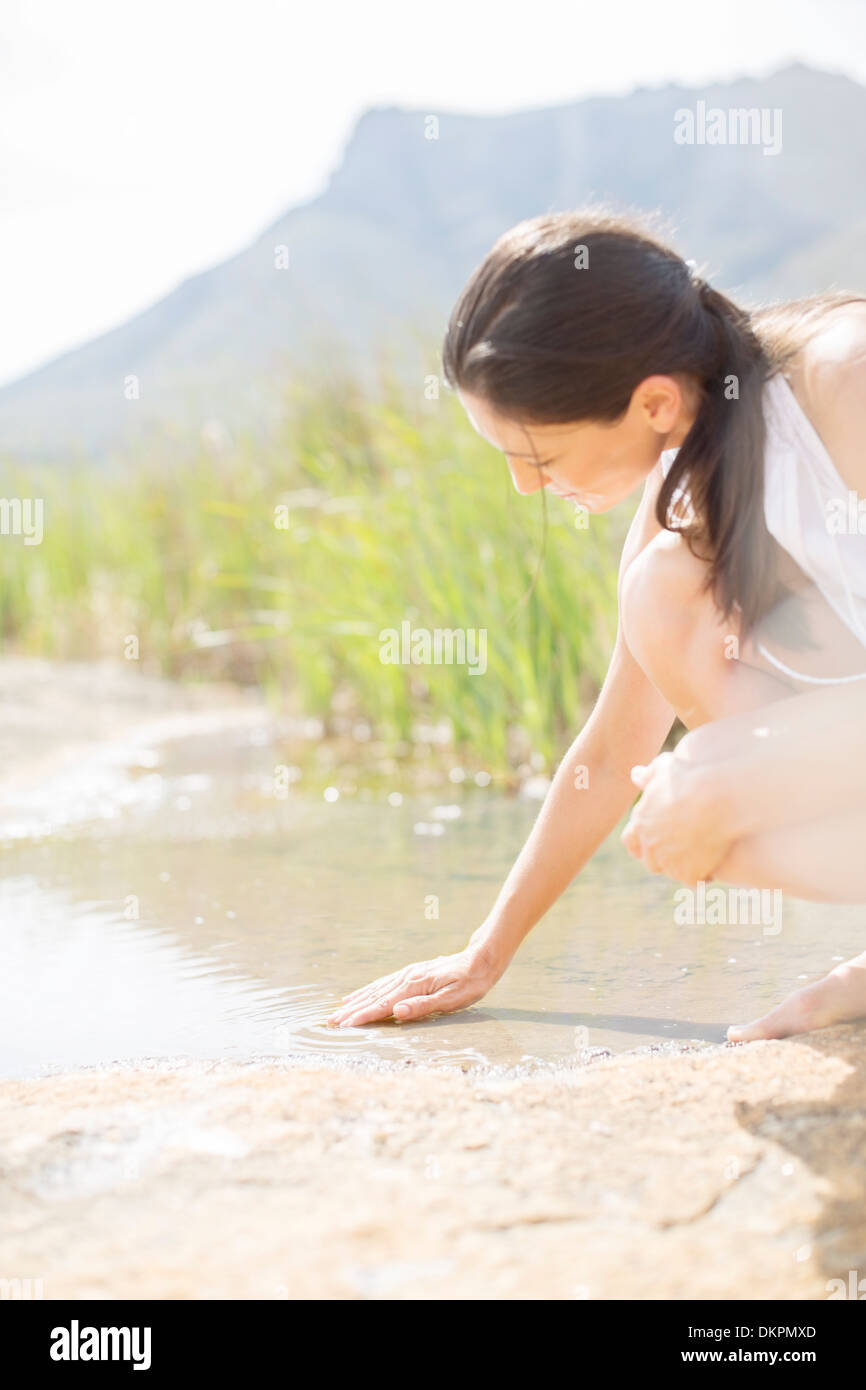 Donna che gioca nel lago rurale Foto Stock