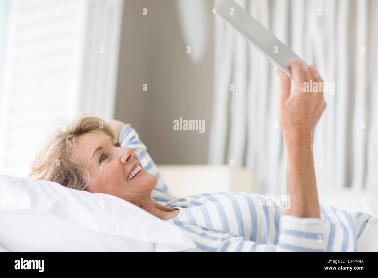 Donna anziana con tavoletta digitale Foto Stock