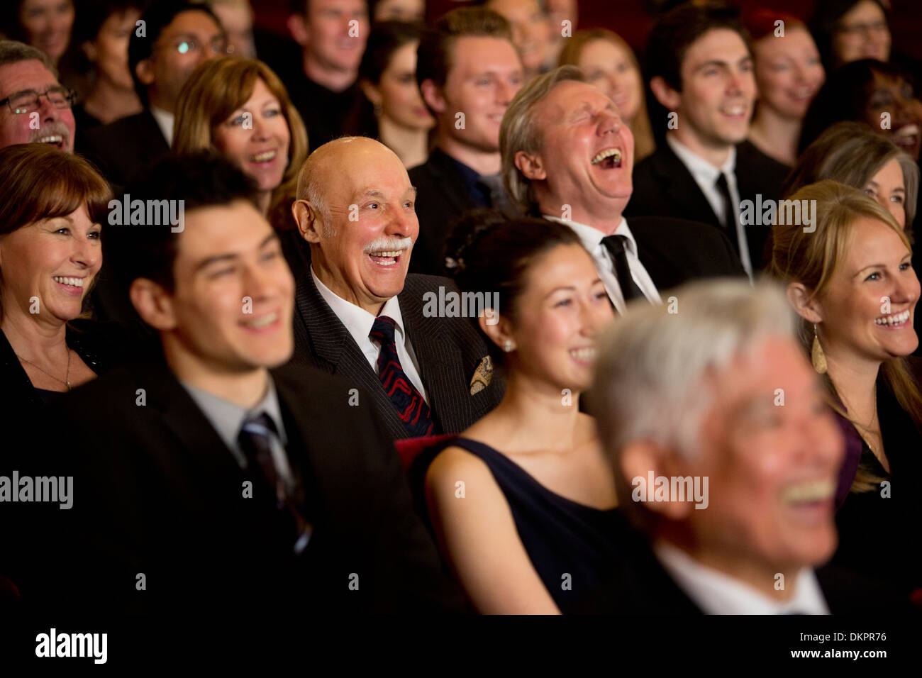 Persone sorridenti e ridere in pubblico in sala Foto Stock