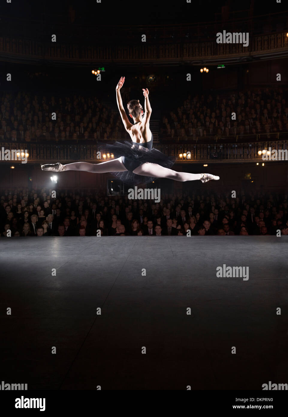 Ballerina mid-aria sul palcoscenico teatrale Foto Stock