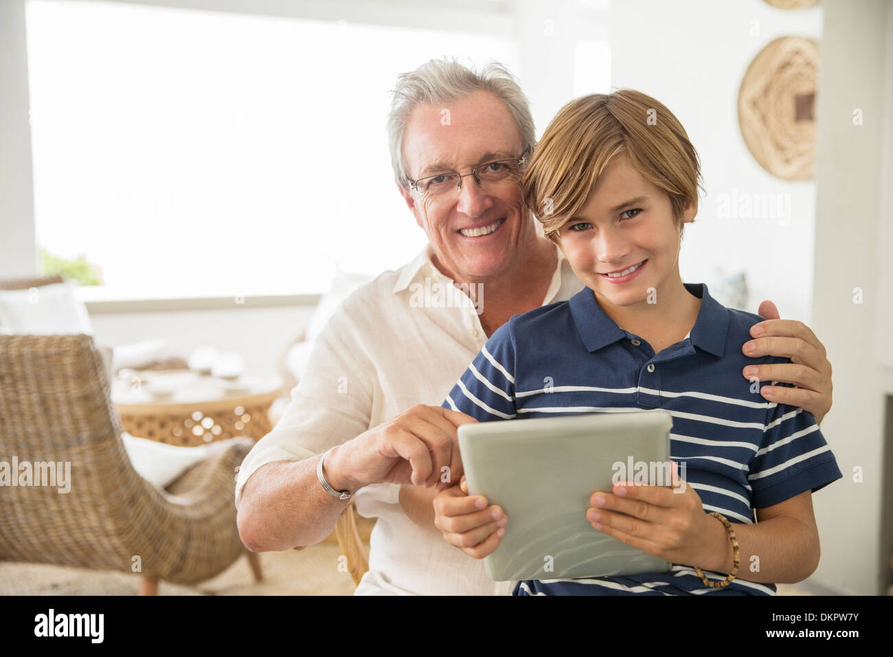 Uomo più anziano e nipote con tavoletta digitale Foto Stock